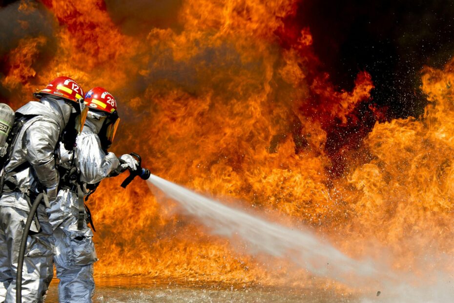 Brave firefighters in action extinguishing a large fire with determination and teamwork.