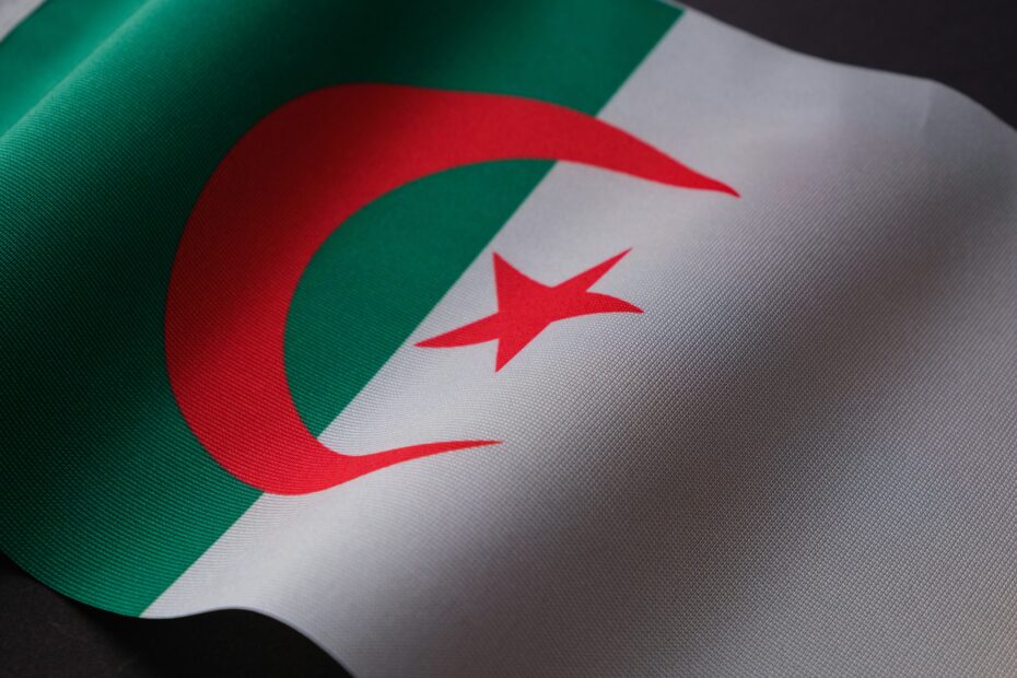 Closeup of the Algerian flag displaying its emblem on textured fabric.