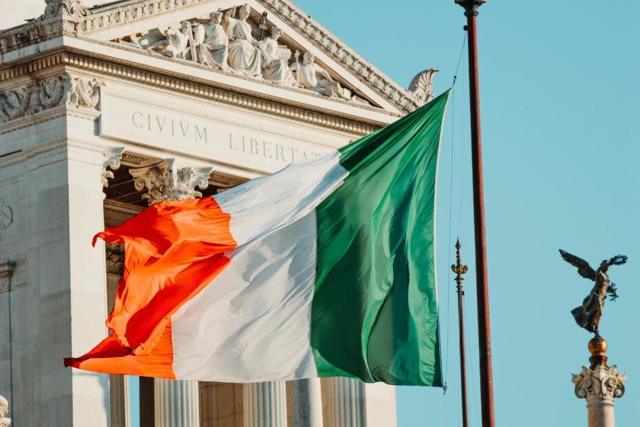 The Irish flag waves gracefully in the breeze at a historic landmark.