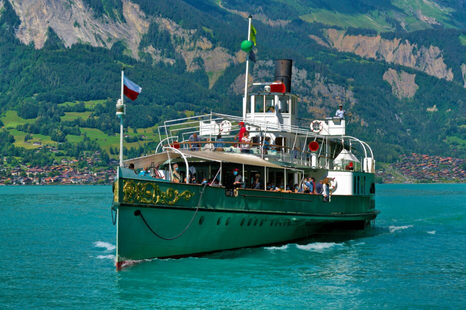 A historic steamship cruises on Lake Brienz with picturesque Swiss Alps in the background.