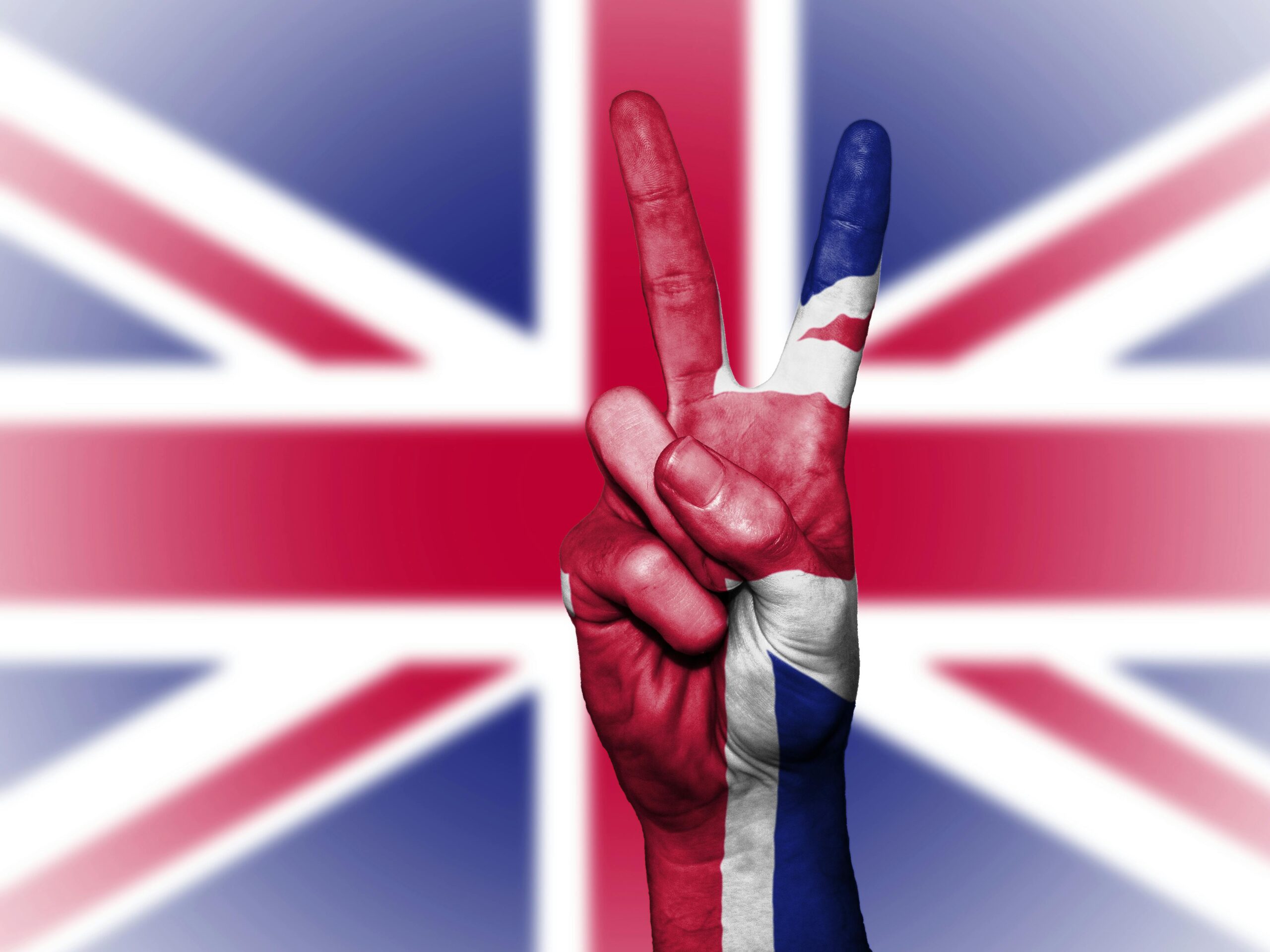 Illustration of a hand showing a peace sign with the UK flag background.