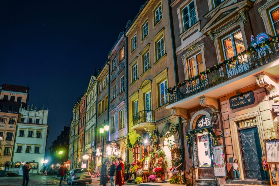 Charming night scene of Warsaw's historic Old Town filled with colorful buildings and lively streets.