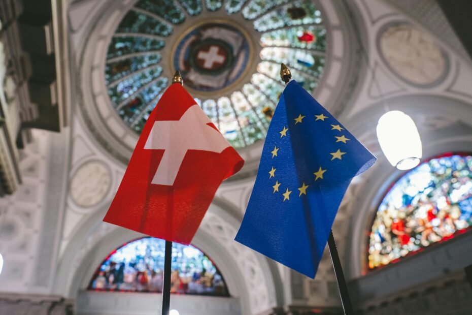 Swiss and EU flags inside a dome with stained glass in Bern, Switzerland.