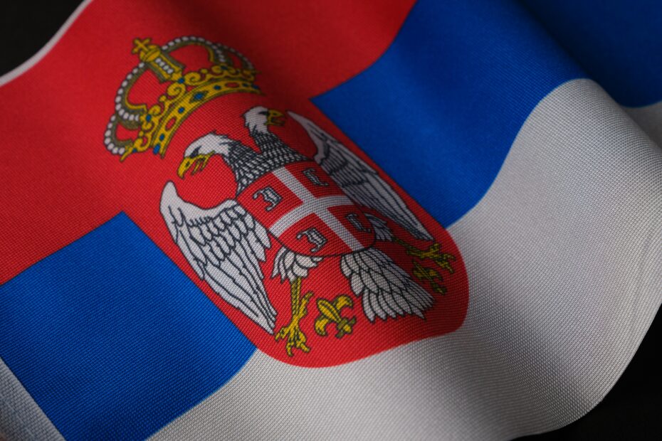 Close-up of the Serbian national flag showcasing its emblem and colors, symbolizing pride.