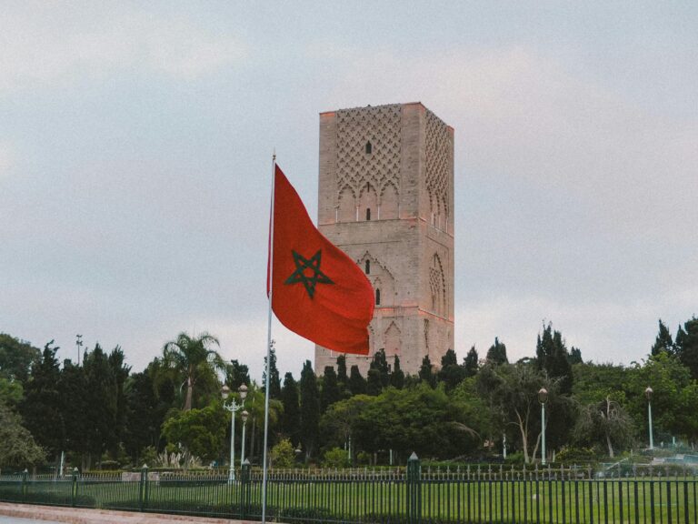 Capture of the iconic Hassan Tower with the Moroccan flag in Rabat, showcasing historic architecture.